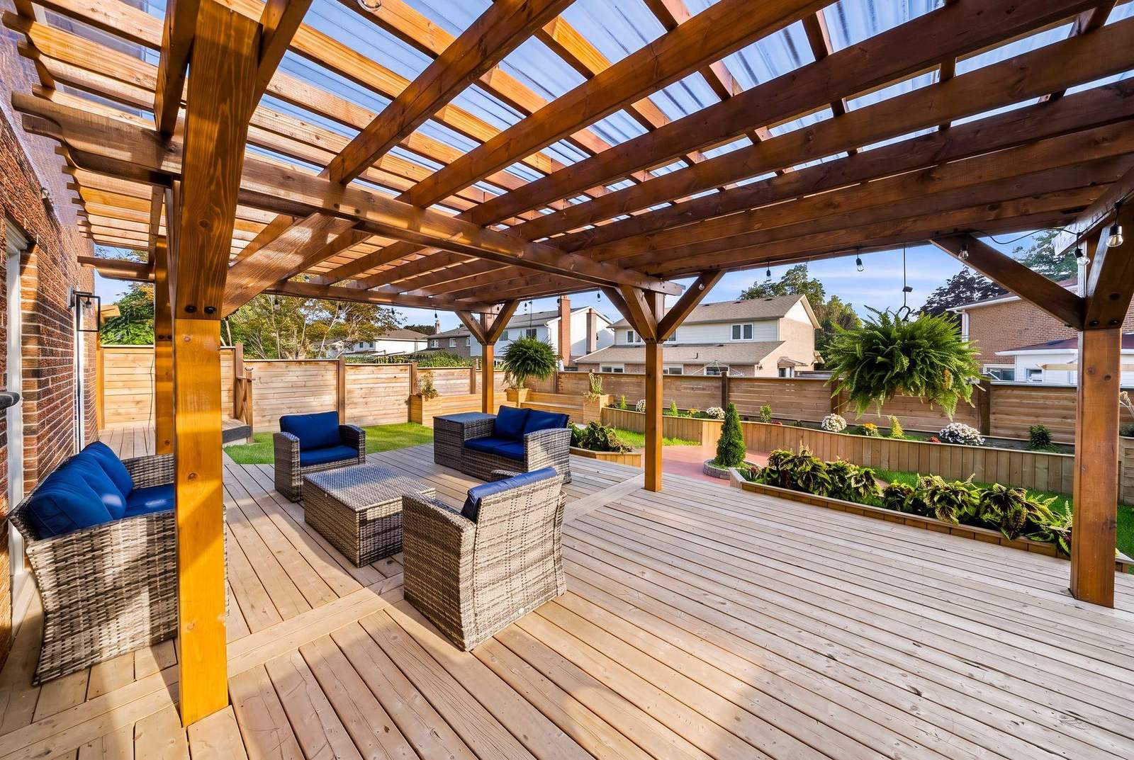 Renovated outdoor living space with a cedar pergola, raised deck and lounge furniture