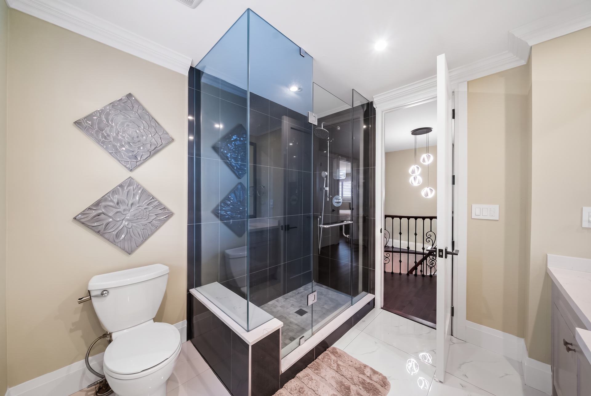 Renovated ensuite with a frameless tinted-glass corner shower and full-height tile