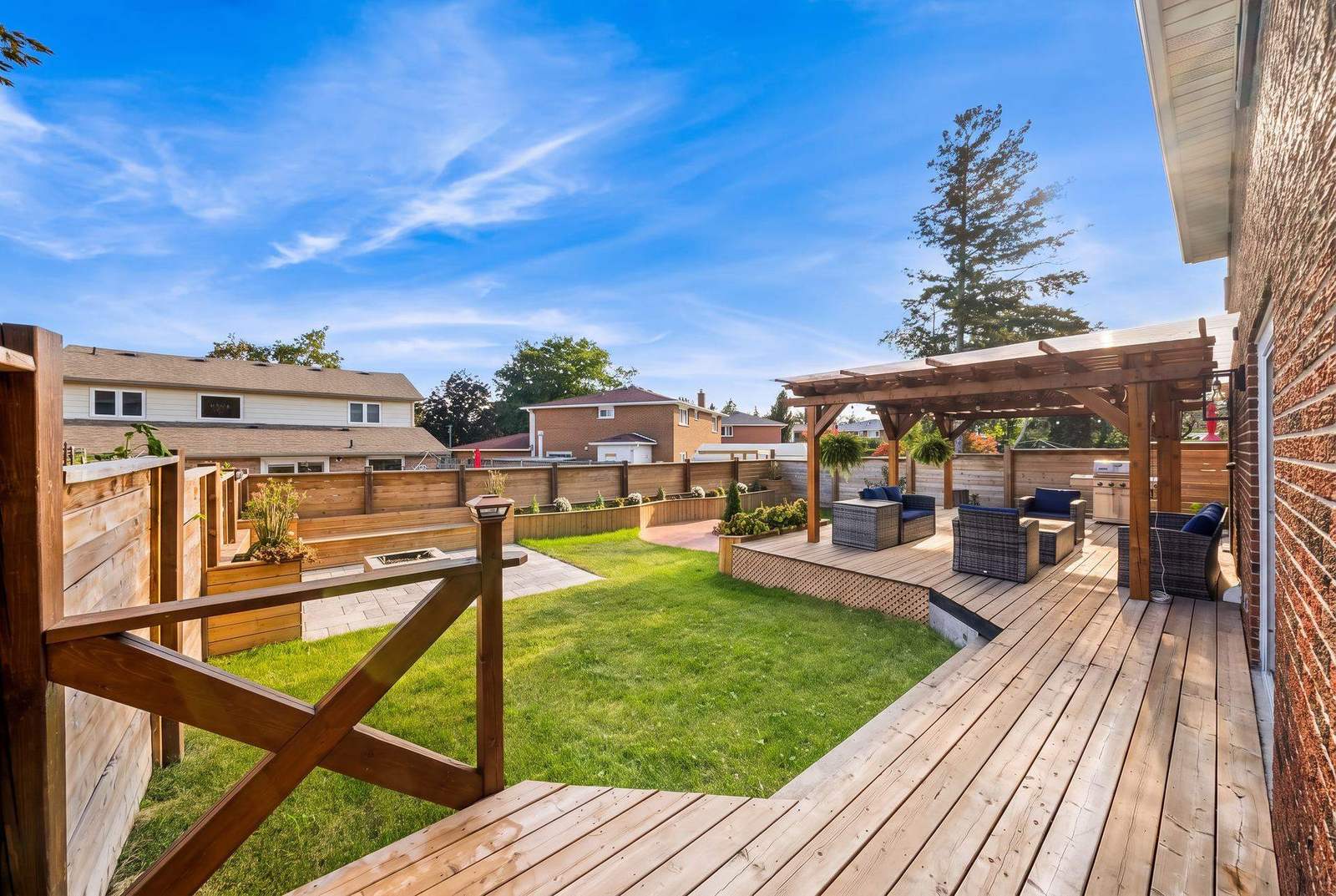Renovated yard overview with new deck, horizontal fence, lawn and planting beds