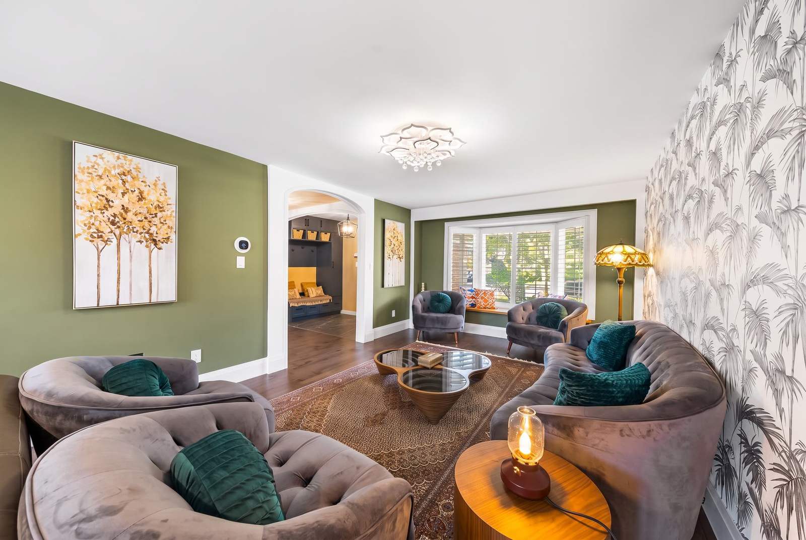 Renovated living room with olive feature walls, arched openings and finish carpentry