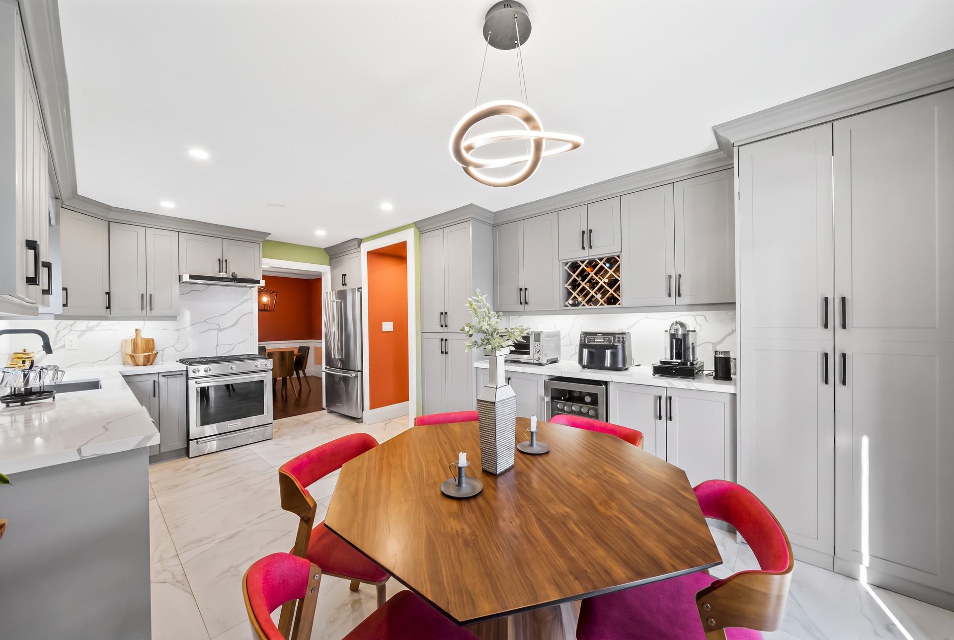 Renovated kitchen with full-height grey cabinetry, wine storage and quartz counters