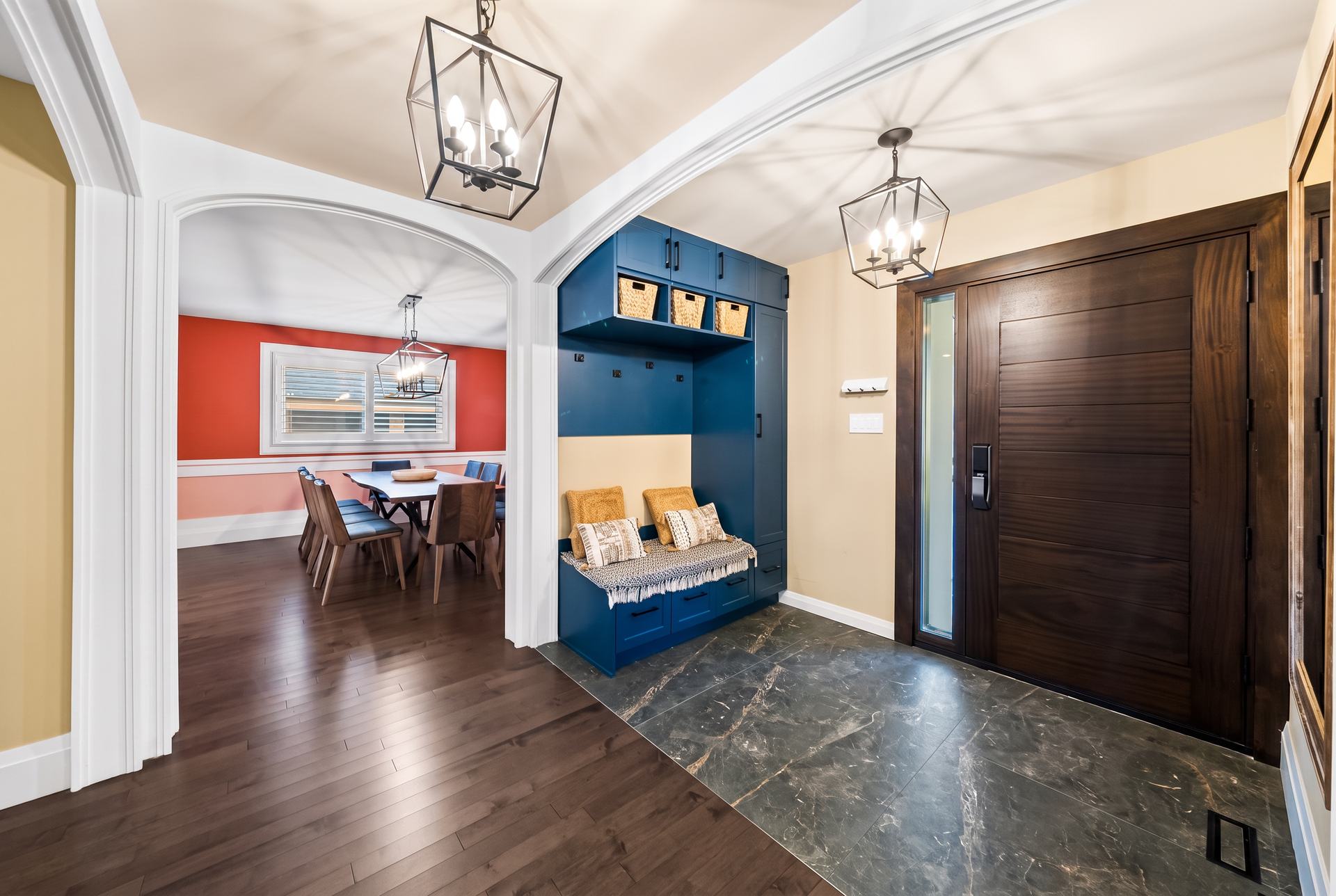 Renovated entry with a custom blue built-in mudroom bench and solid-wood front door