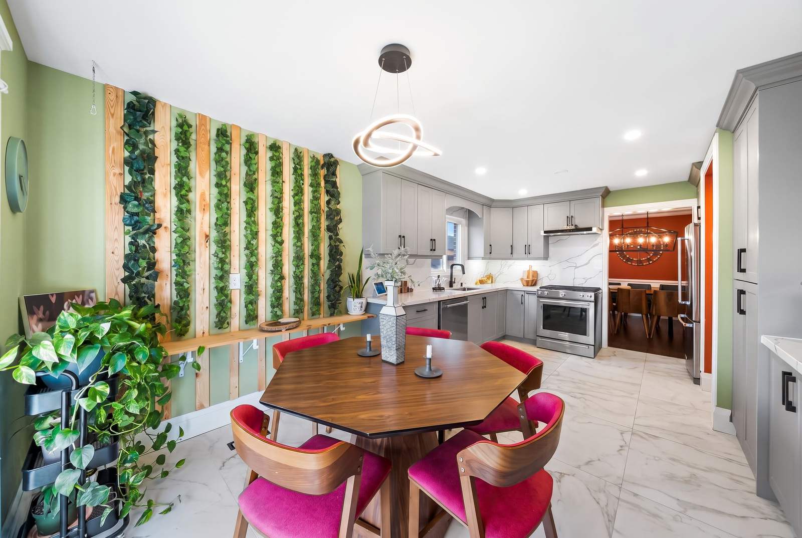 Renovated main-floor kitchen with grey cabinetry, marble-look floors and a custom wood-slat living wall